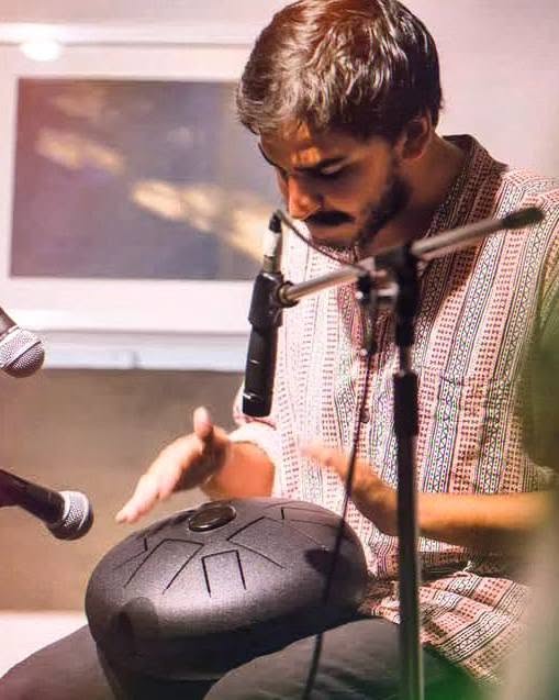 Close-up of Ashim Bery playing a steel tongue drum between two microphones
